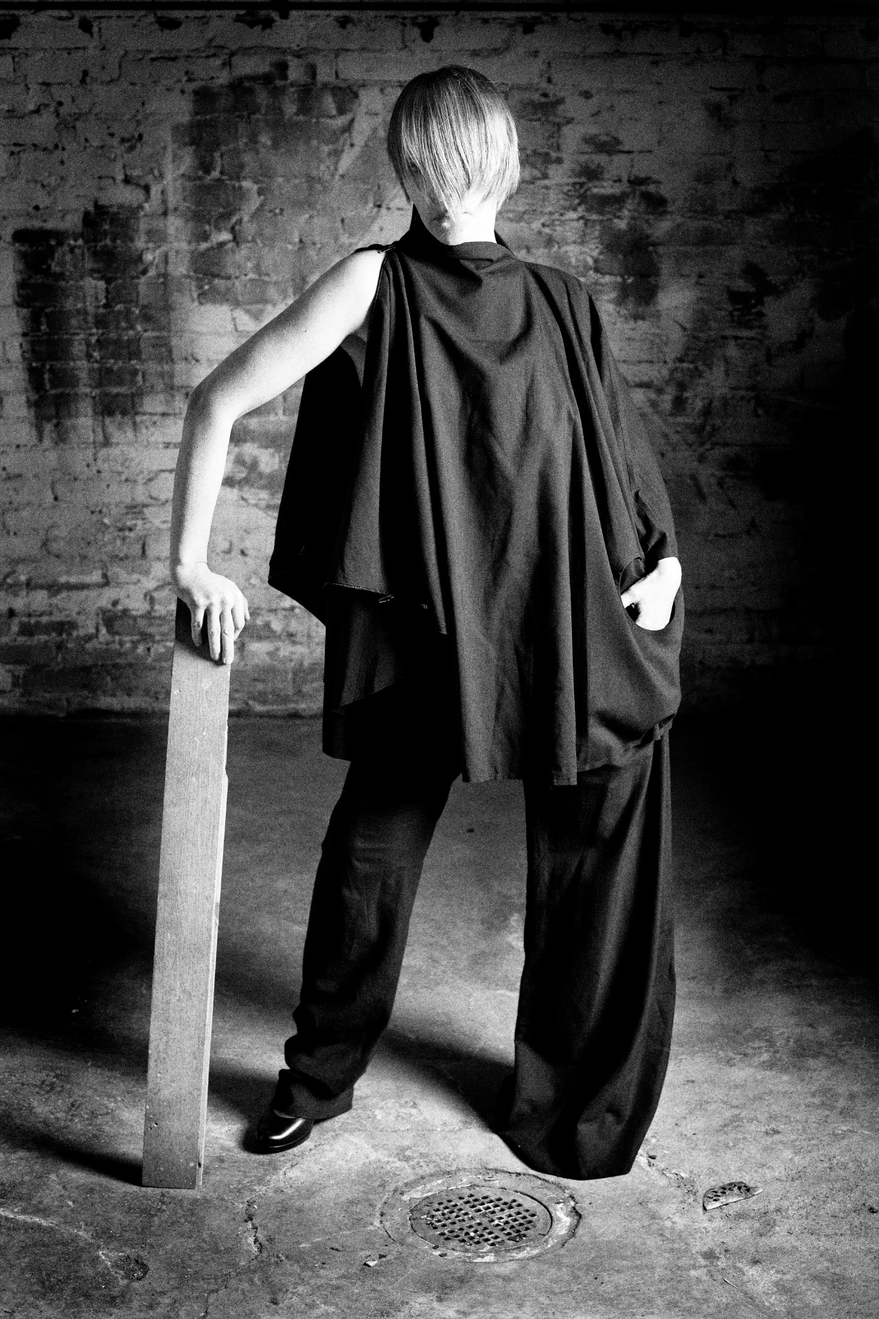 Henkilö seisoo hieman kääntyneenä, yllään puuvillabatistista valmistetut jakku ja housut.